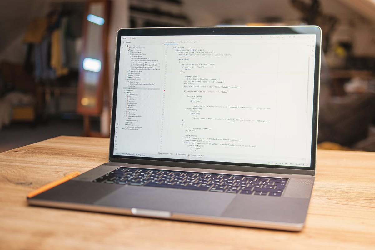 Open laptop with visible code on screen on a wooden desk in a modern, cozy workspace.