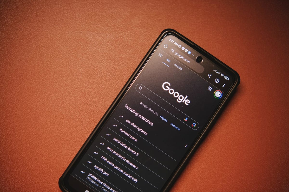 A smartphone displaying Google Search trends on a table at night.
